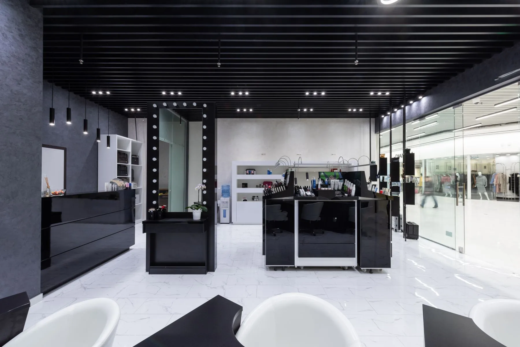 A monochrome barbershop interior with a long mirror wall
